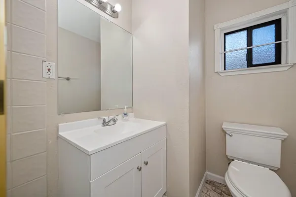 a bathroom with a toilet sink and mirror