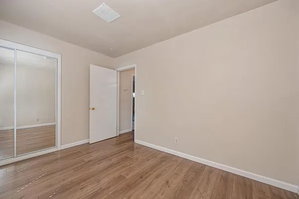 a view of an empty room with wooden floor