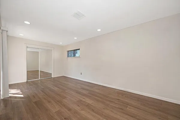 a view of an empty room with wooden floor
