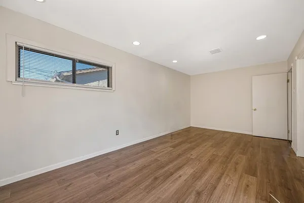 a view of an empty room with wooden floor