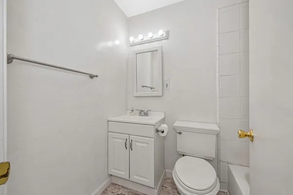 a bathroom with a toilet a sink and mirror