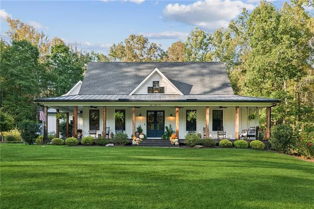 a front view of a house with a garden and trees