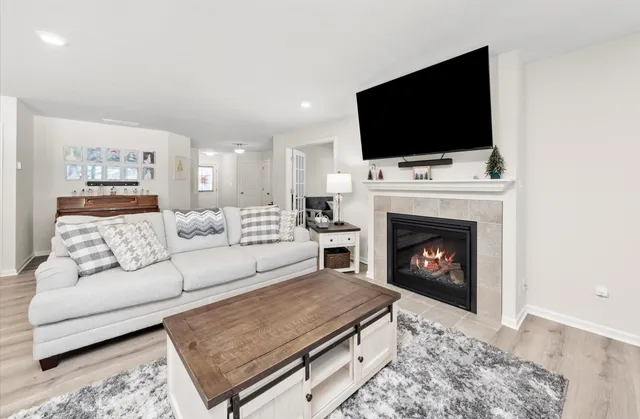 a living room with furniture a flat screen tv and a fireplace