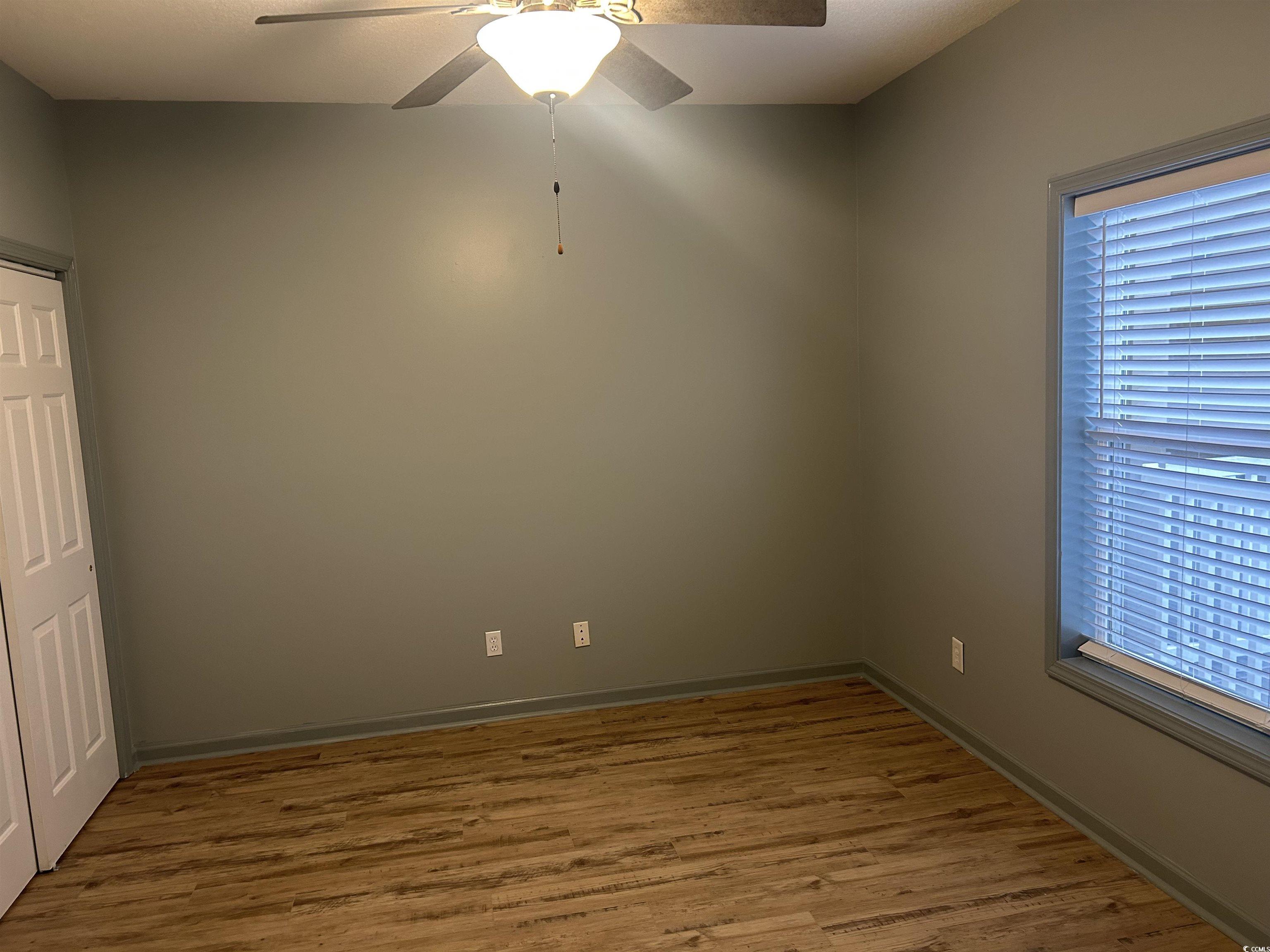 4104 Pinehurst Circle, Unit 2G Little River, SC 29566 - Photo 9 of 17 Empty room with ceiling fan and wood finished floors