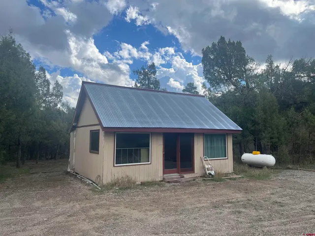 a view of a house with a yard and a tree