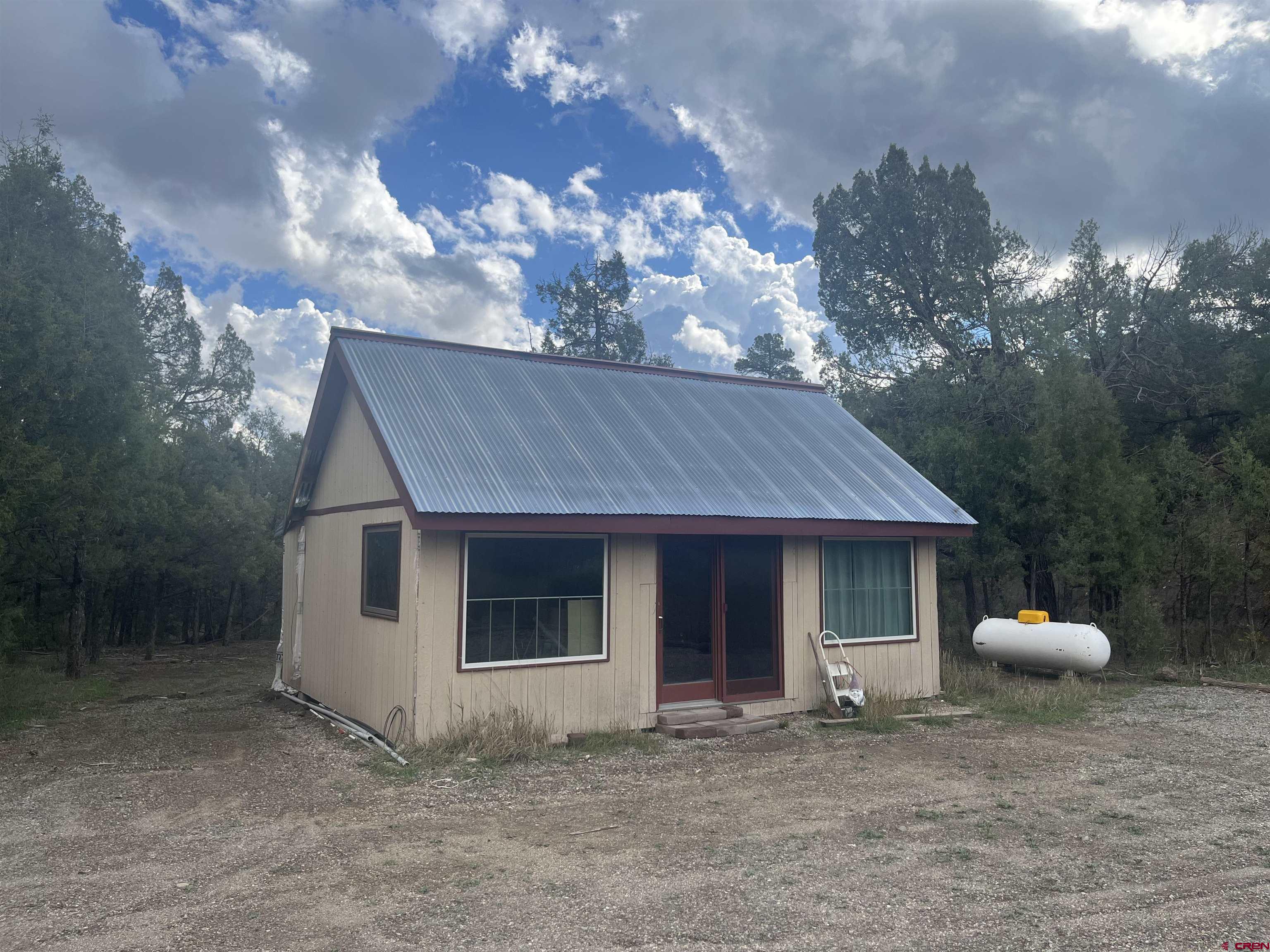 a view of a house with a yard and a tree