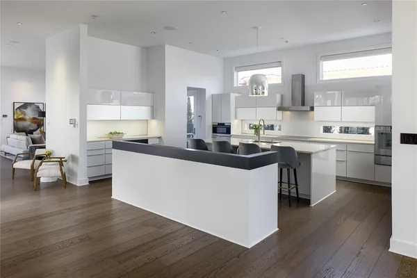 a kitchen with stainless steel appliances a sink cabinets and wooden floor