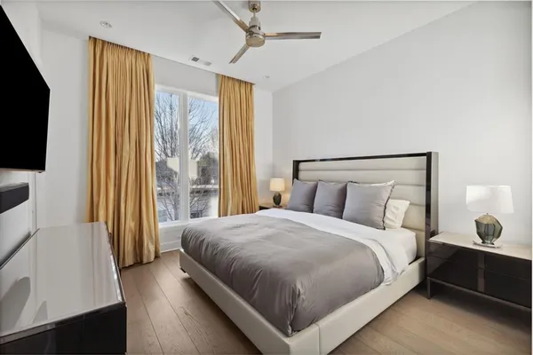 a bedroom with a bed and a flat tv screen on dresser