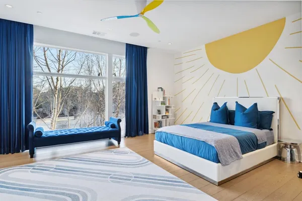 a bedroom with a bed lamps and a large window with outer view