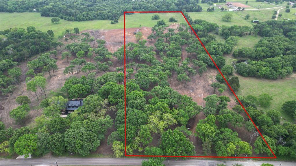 an aerial view of residential house with outdoor space and trees all around