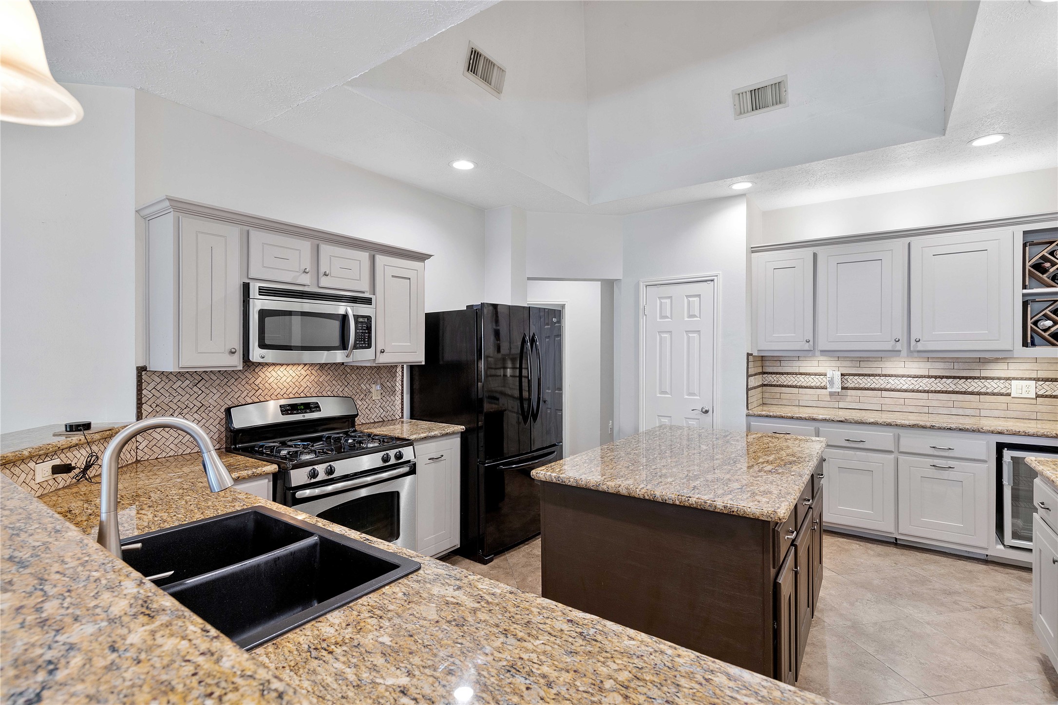 1707 Moston Drive Spring, TX 77386 - Photo 14 of 41 a kitchen with granite countertop a stove sink and refrigerator
