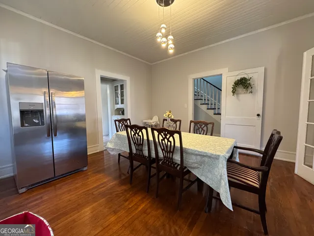 a dining room with furniture a chandelier and wooden floor