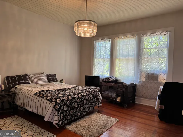 a bedroom with bed and a large window