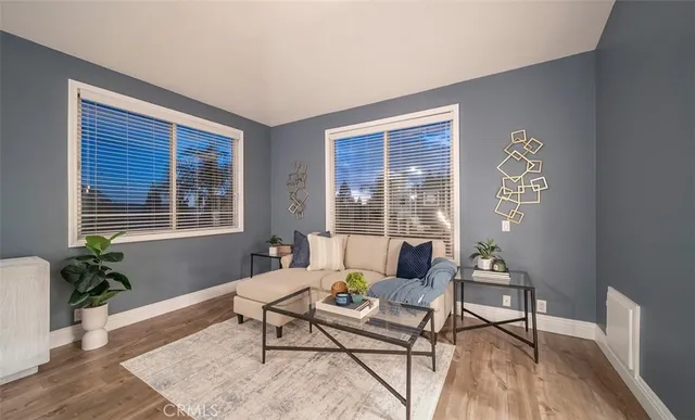 a view of a living room and a livingroom with furniture wooden floor and a chandelier