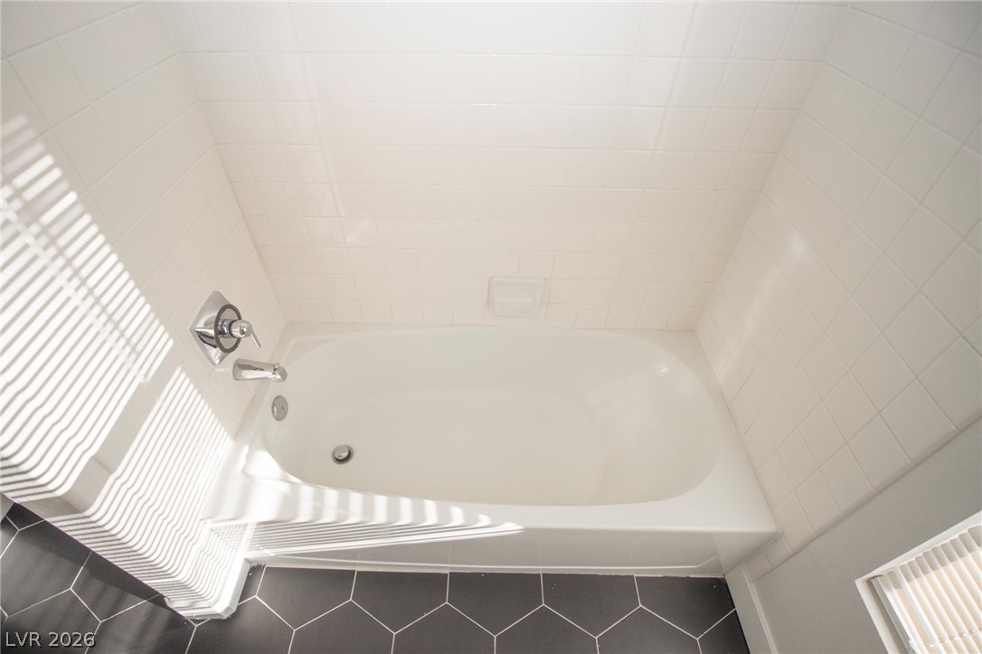 1468 Reef Ridge Court Las Vegas, NV 89128 - Photo 14 of 22 Clean lines define this pristine bathroom, ready for relaxation with its classic white bathtub.
