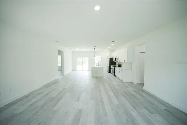 a kitchen with stainless steel appliances a sink a stove a refrigerator cabinets and a wooden floor