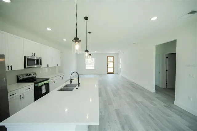 a kitchen with stainless steel appliances a refrigerator sink and microwave