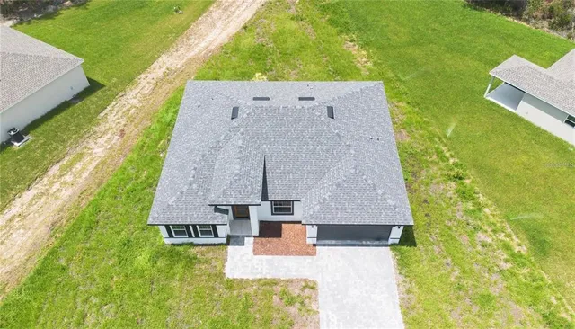 an aerial view of a house with a garden and swimming pool