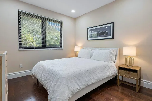 a living room with furniture a flat screen tv and a lamp