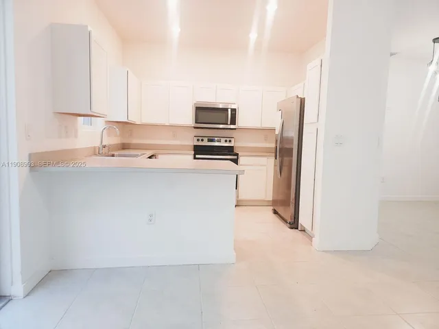 a front view of a house with a yard and potted plants