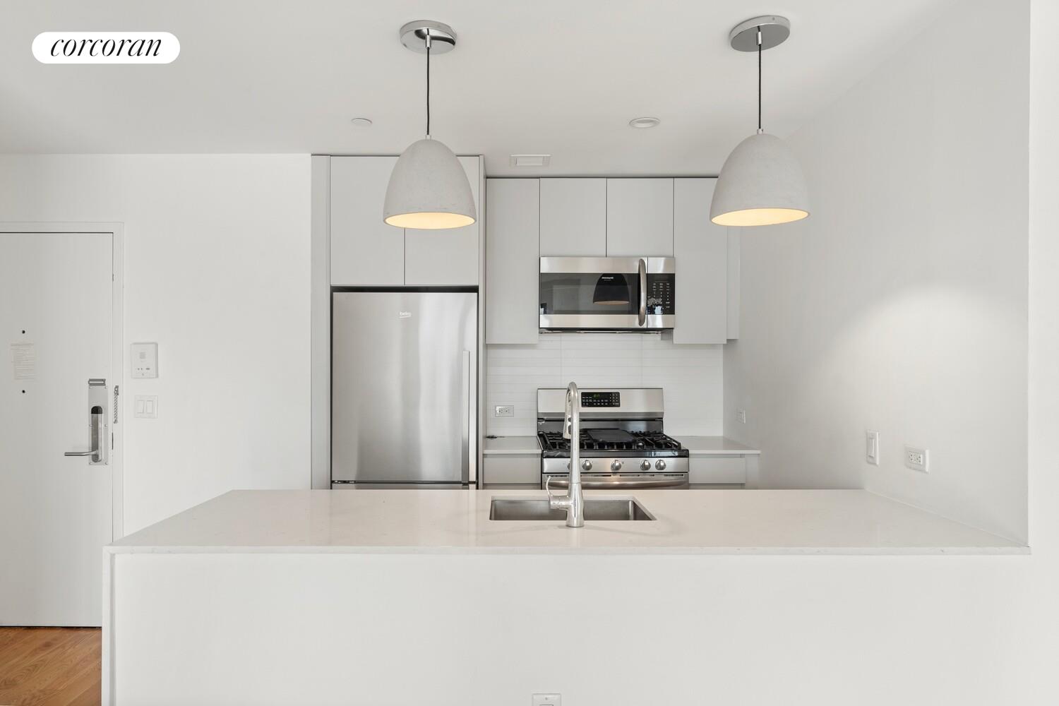 123 Hope Street, Unit 6R Brooklyn, NY 11211 - Photo 4 of 14 a kitchen with kitchen island a counter space a sink and appliances