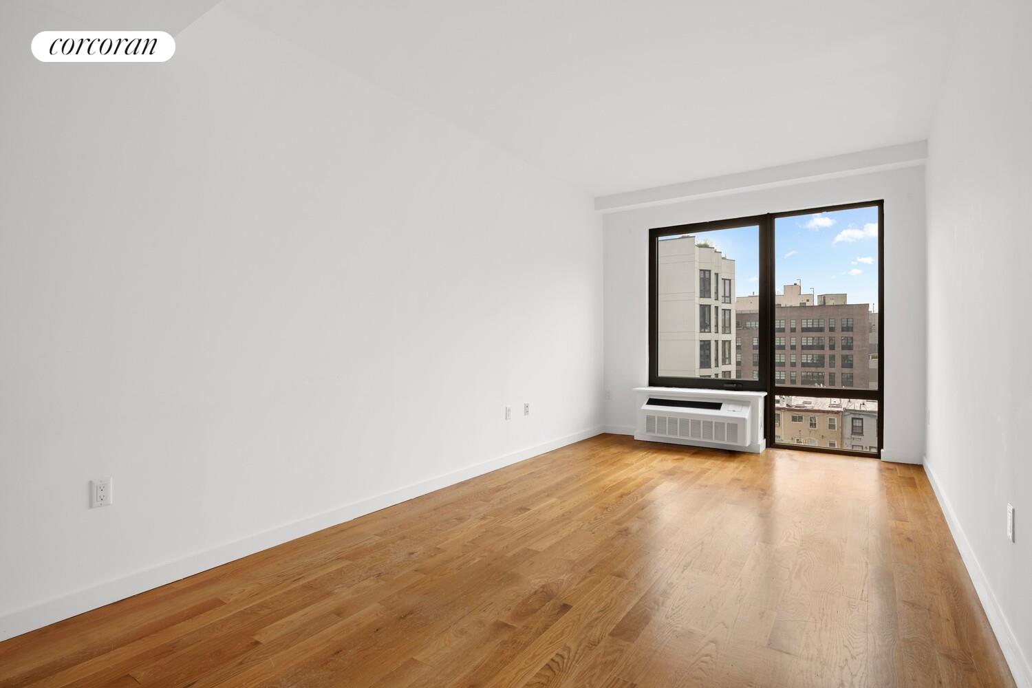 123 Hope Street, Unit 6R Brooklyn, NY 11211 - Photo 7 of 14 a view of an empty room with wooden floor and a window