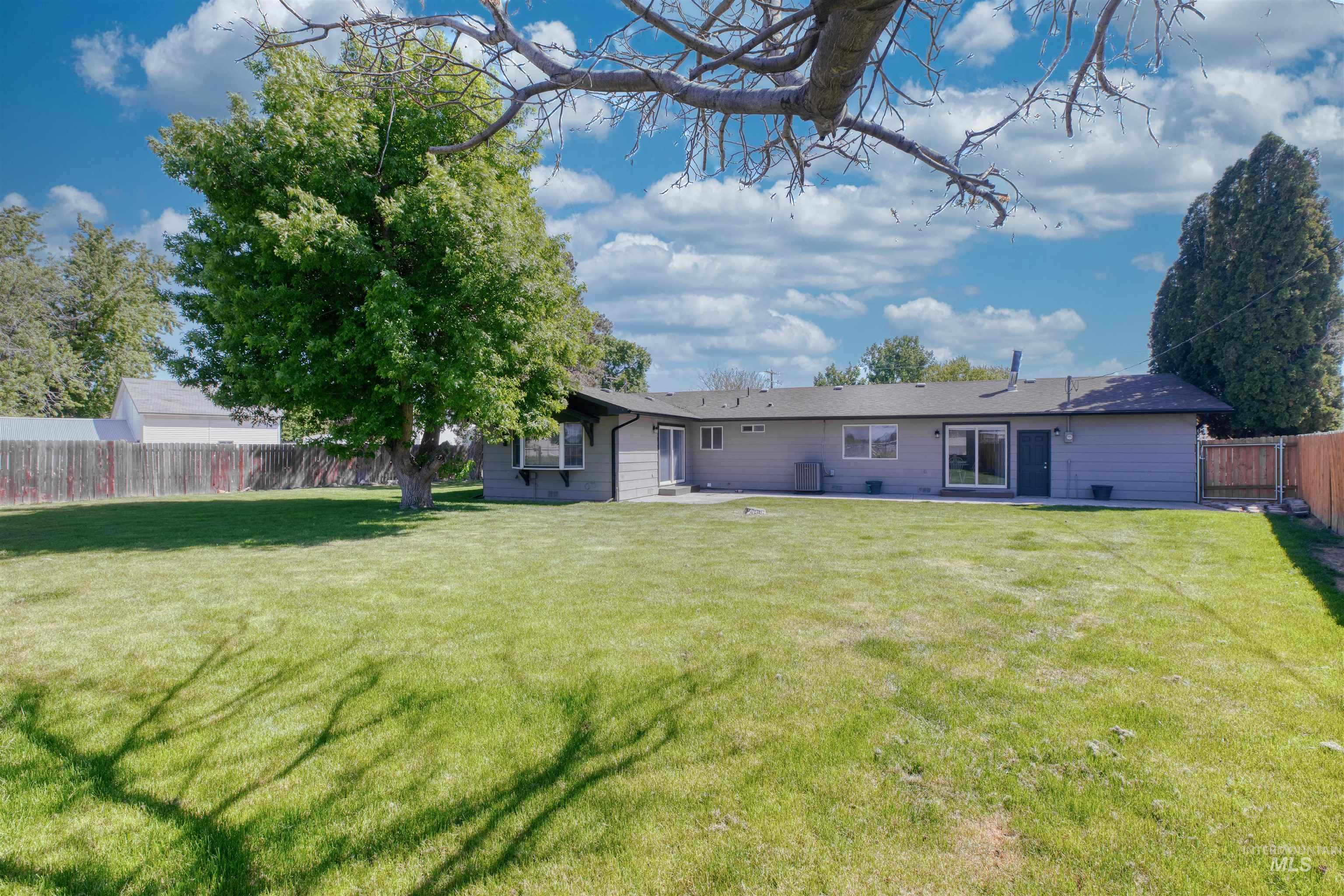 20803 Friends Road Greenleaf, ID 83626 - Photo 26 of 39 Expansive backyard featuring a large green lawn, mature trees, and a full privacy fence