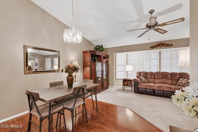 a living room with furniture dining table a window and a chandelier