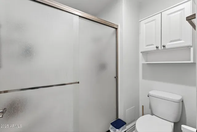 a white toilet sitting next to a shower in a bathroom