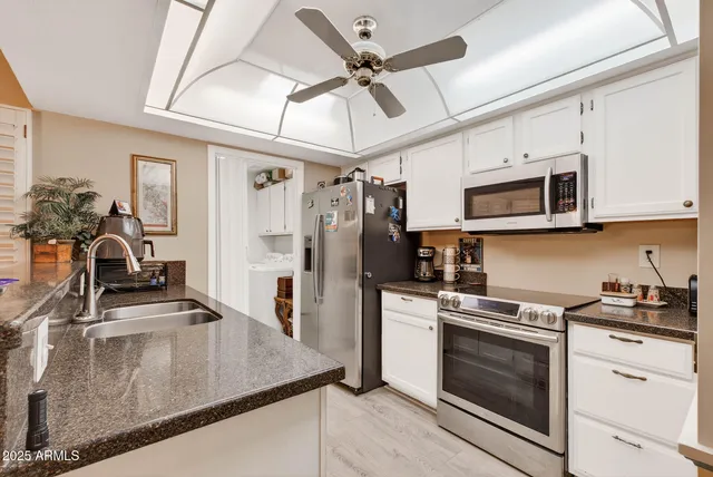 a kitchen with stainless steel appliances granite countertop a stove refrigerator and microwave