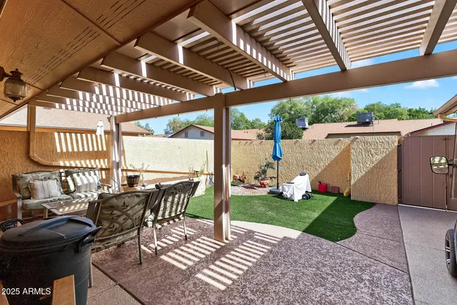a view of a patio with table and chairs with wooden floor and fence