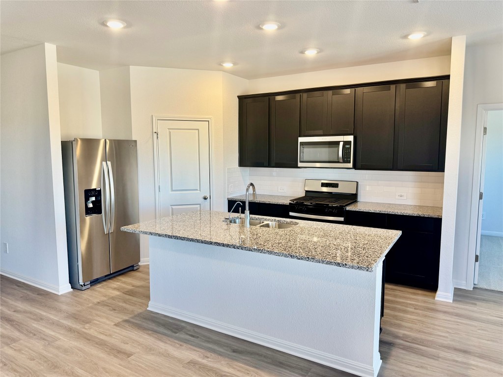 144 Boondoggle Ridge Cedar Creek, TX 78612 - Photo 2 of 7 a modern kitchen with stainless steel appliances granite countertop a stove a refrigerator and a sink