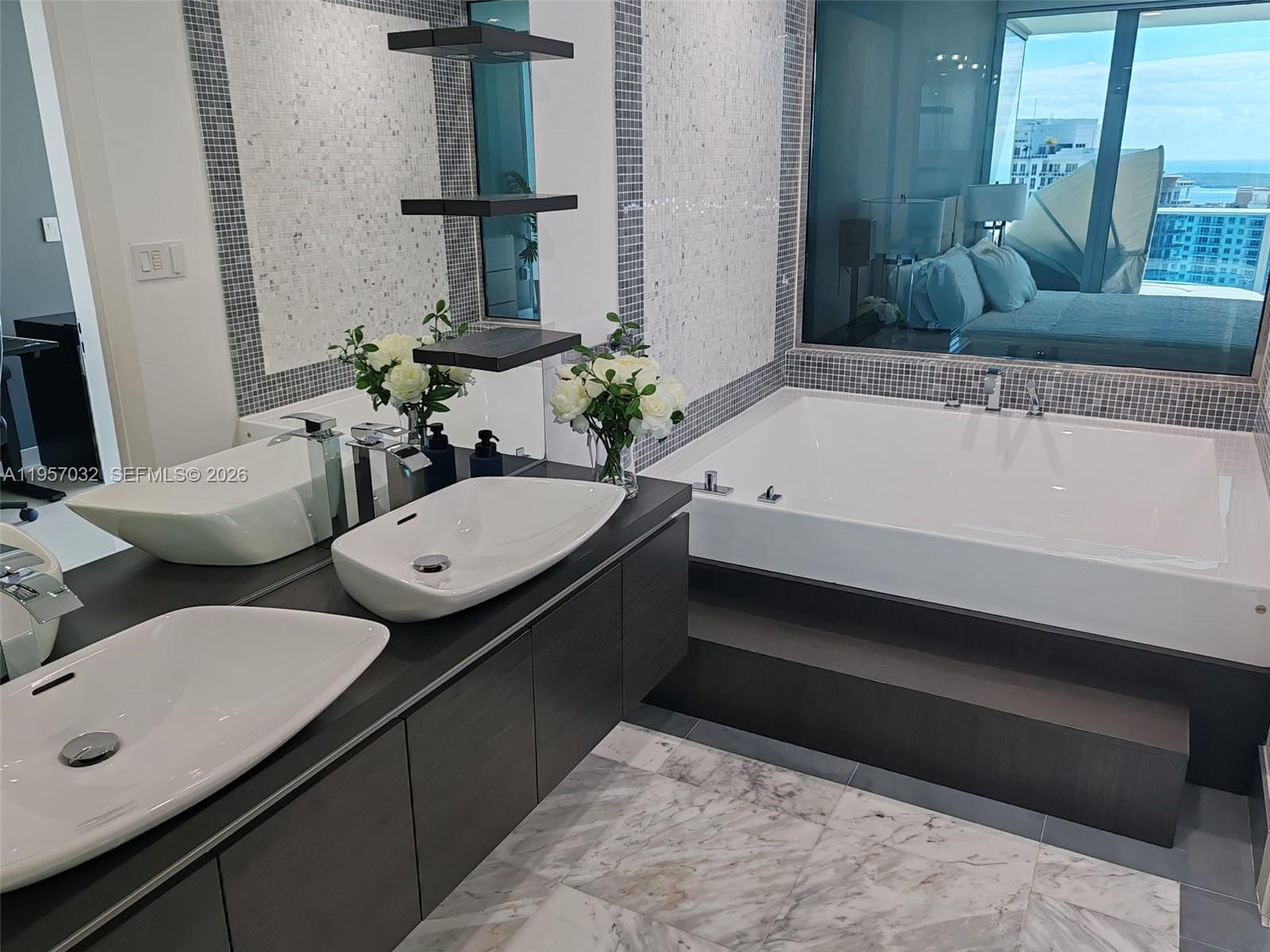 200 Biscayne Blvd Way, Unit 3907 Miami, FL 33131 - Photo 14 of 20 a bathroom with a tub sink and mirror