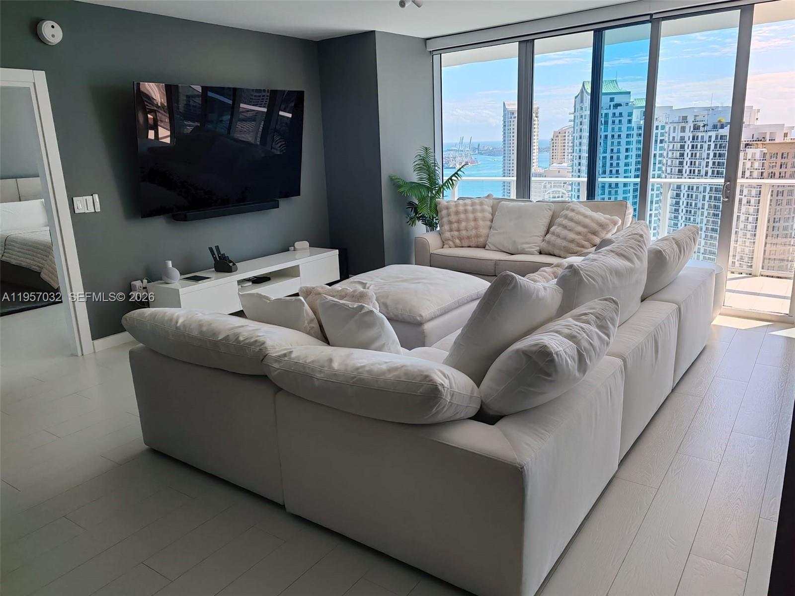 200 Biscayne Blvd Way, Unit 3907 Miami, FL 33131 - Photo 6 of 20 a living room with furniture and a flat screen tv