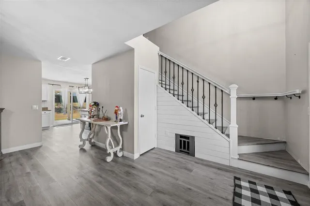 a view of a livingroom with wooden floor and furniture