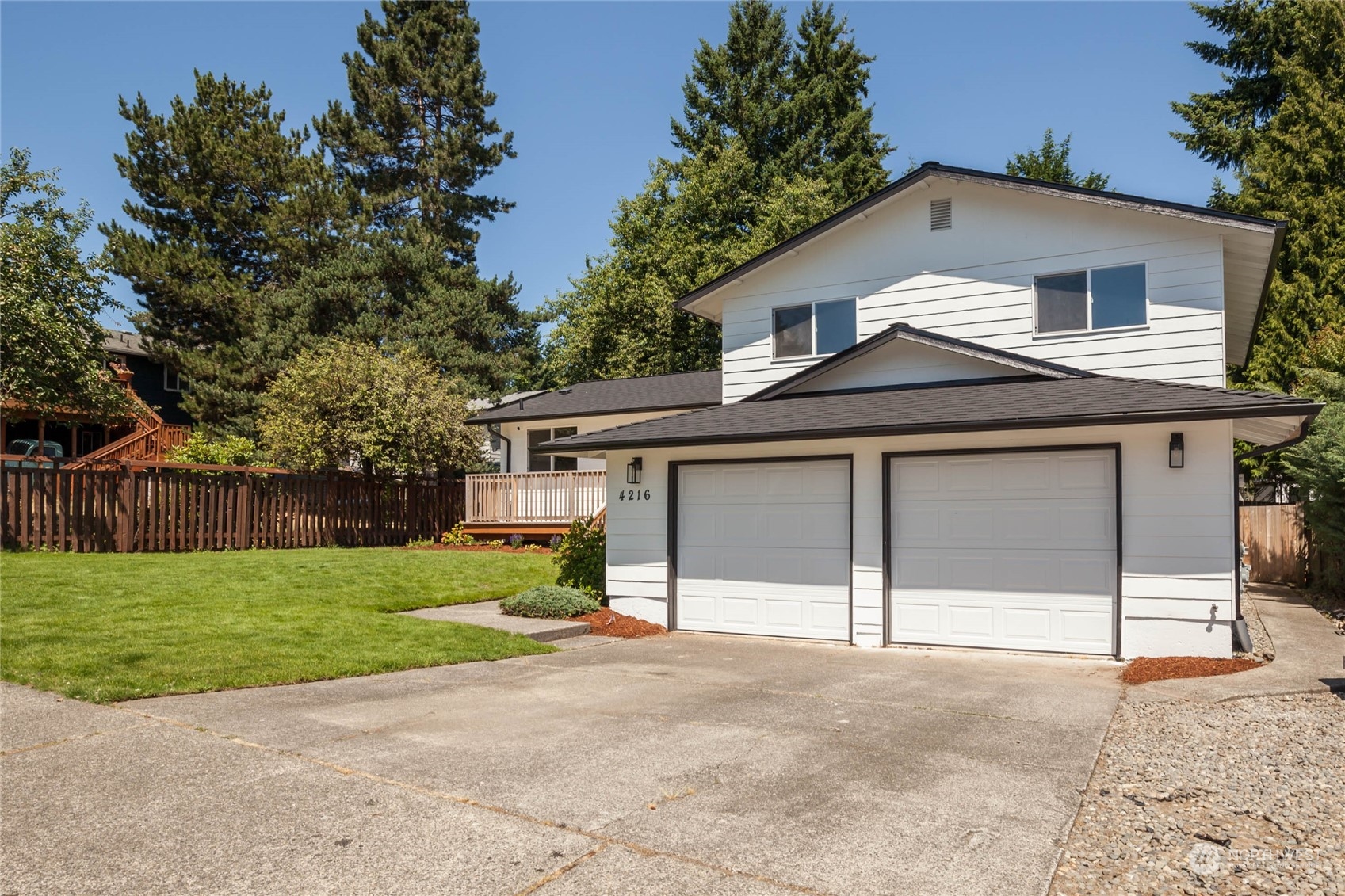 4216 Northeast 20th Street Renton, WA 98059 - Photo 25 of 26 a front view of a house with a yard and garage