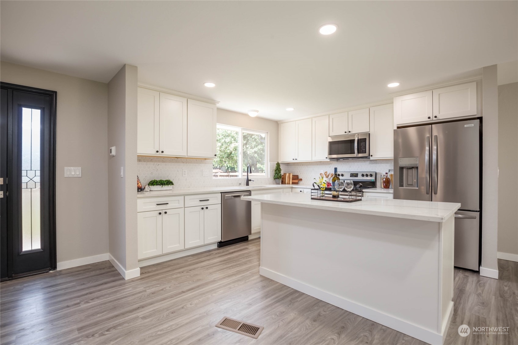 4216 Northeast 20th Street Renton, WA 98059 - Photo 3 of 26 a kitchen with white cabinets and stainless steel appliances