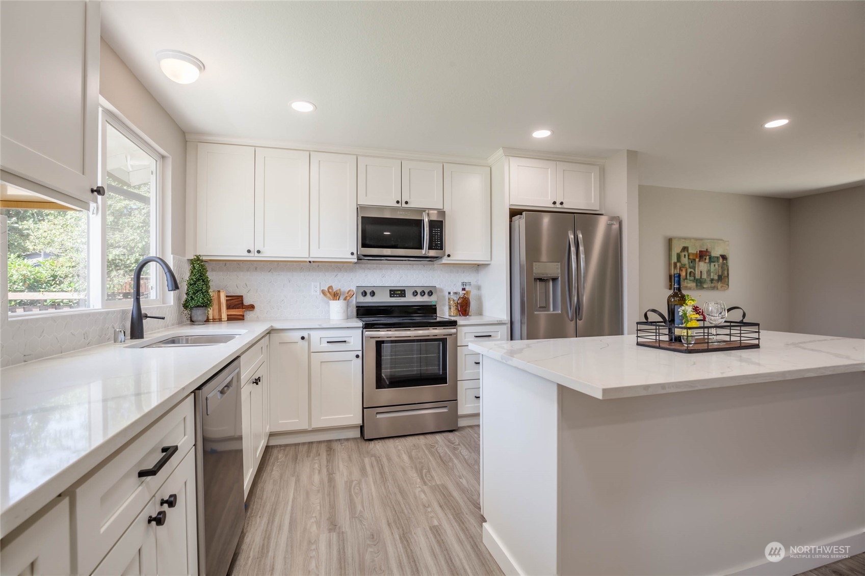 4216 Northeast 20th Street Renton, WA 98059 - Photo 6 of 26 a kitchen with a sink a stove a refrigerator a center island and a window