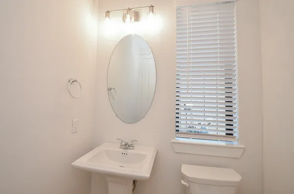 a bathroom with a sink a toilet and a mirror