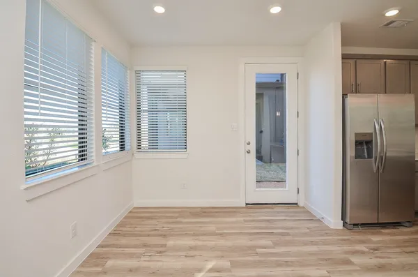 a large kitchen with cabinets wooden floor and stainless steel appliances