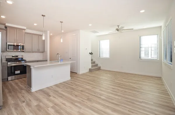 a kitchen with kitchen island a sink stainless steel appliances and cabinets