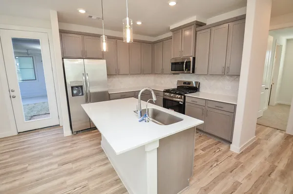 a kitchen with stainless steel appliances granite countertop a sink and a stove top oven