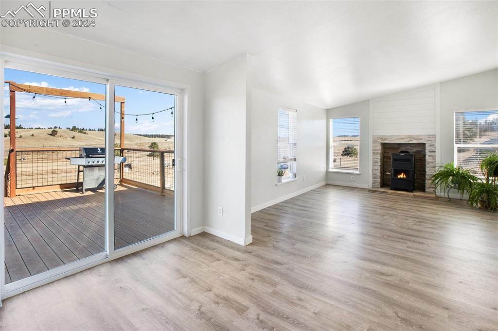 69 Aspen Drive Divide, CO 80814 - Photo 5 of 50 an empty room with wooden floor fireplace and windows