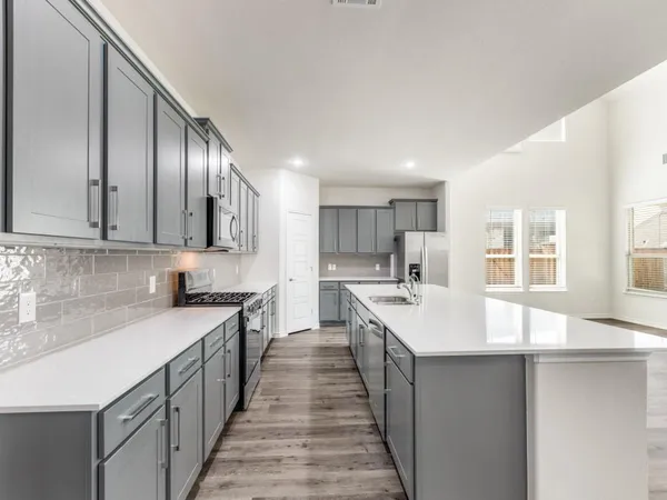 a kitchen with sink cabinets and wooden floor