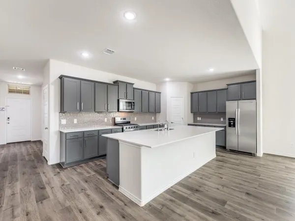 a kitchen with white cabinets sink and stove