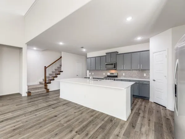 a view of kitchen with wooden floor and electronic appliances