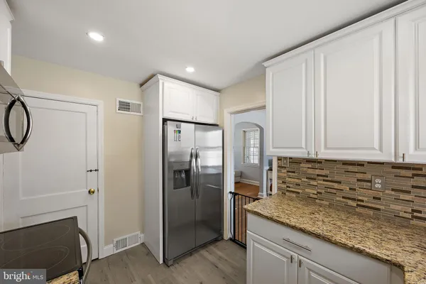 a kitchen with stainless steel appliances granite countertop a refrigerator and a sink