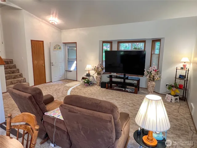 a kitchen with stainless steel appliances granite countertop a stove a refrigerator a kitchen island a dining table and chairs with wooden floor