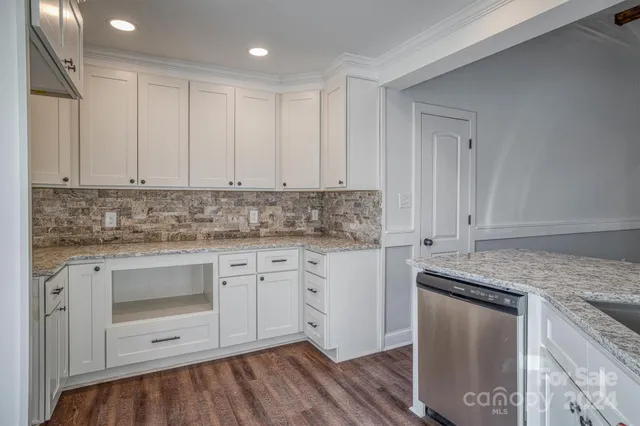 a kitchen with granite countertop white cabinets and white appliances