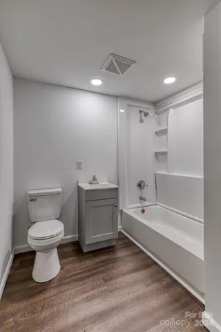 a bathroom with a toilet sink a mirror and bathtub